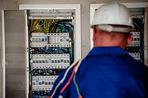 Worker electrician cables distribution board