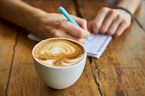 Cappuccino coffee with person writing