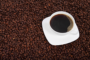 Cup of black coffee on coffee beans